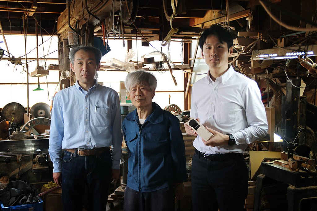 Craftsman and members of the Kakuri standing in a Japanese tool workshop, showcasing the tradition and skill passed down through generations of artisans.